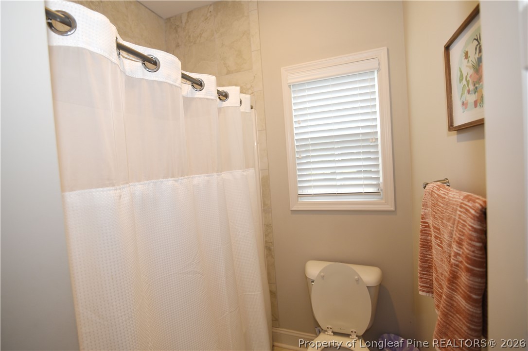 1843 Meadow Road Lumberton, NC 28358 - Photo 25 of 35 a bathroom with a toilet and a shower curtain