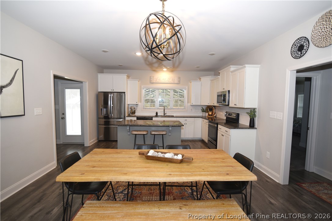 1843 Meadow Road Lumberton, NC 28358 - Photo 8 of 35 a kitchen with stainless steel appliances kitchen island granite countertop a refrigerator a stove top oven a sink dishwasher and white cabinets with wooden floor