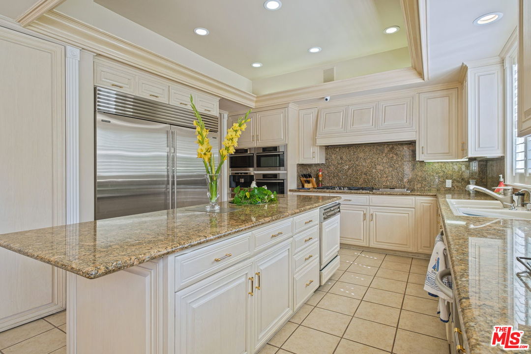 511 North Canon Drive Beverly Hills, CA 90210 - Photo 15 of 34 a kitchen with a sink refrigerator and cabinets