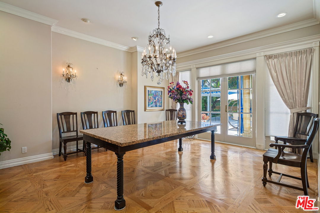 511 North Canon Drive Beverly Hills, CA 90210 - Photo 16 of 34 a dining room with furniture a chandelier and wooden floor