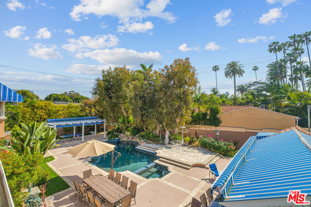511 North Canon Drive Beverly Hills, CA 90210 - Photo 25 of 34 a view of a patio with table and chairs with plants and wooden fence