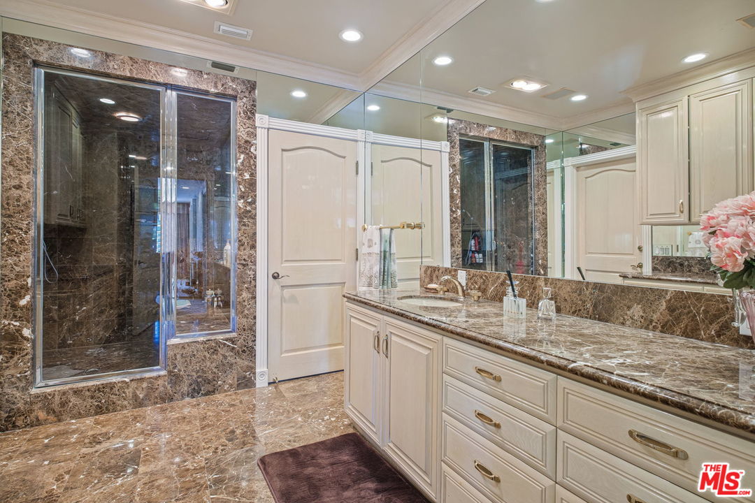 511 North Canon Drive Beverly Hills, CA 90210 - Photo 26 of 34 a bathroom with a granite countertop sink mirror and shower