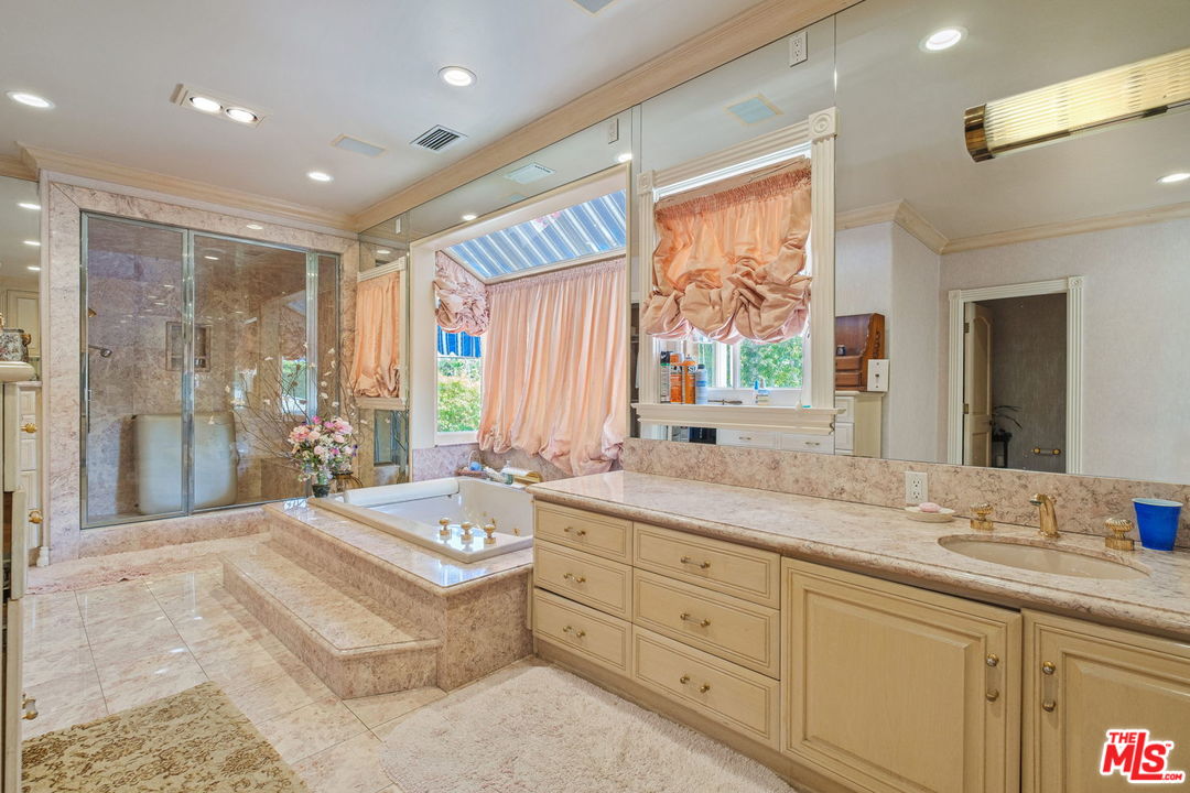 511 North Canon Drive Beverly Hills, CA 90210 - Photo 27 of 34 a spacious bathroom with a double vanity sink large mirror and a shower