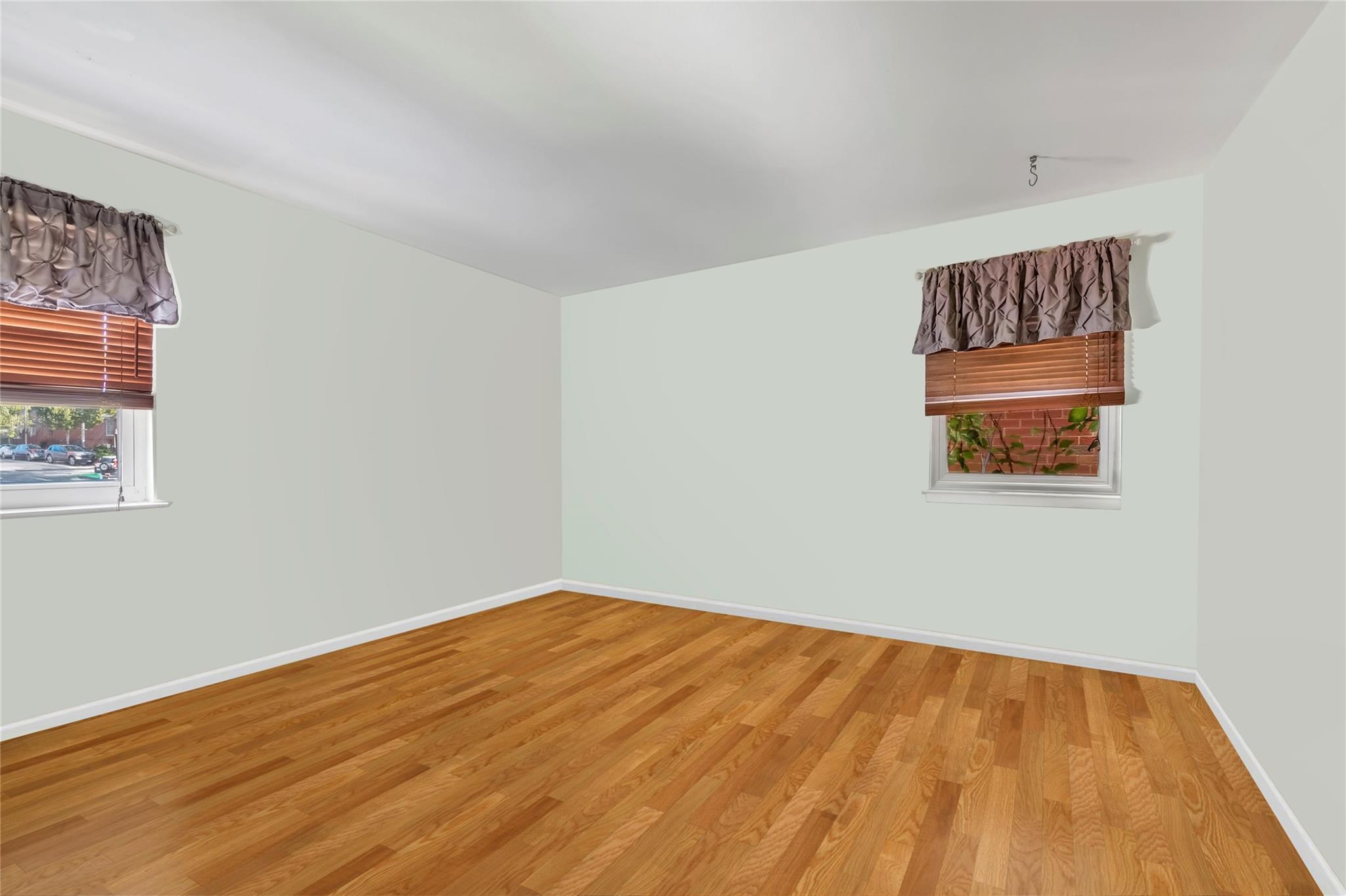 Unfurnished room featuring light wood finished floors and baseboards