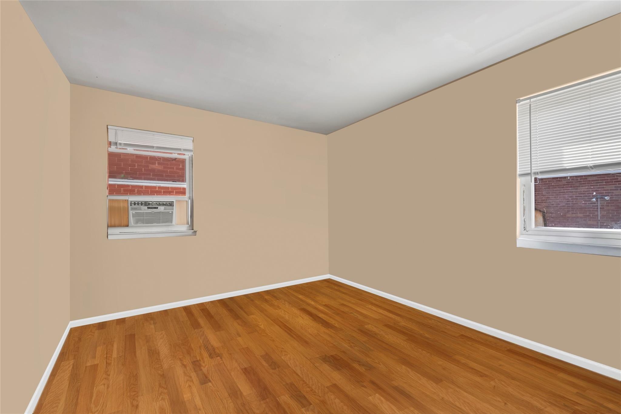Spare room with baseboards, wood finished floors, and cooling unit