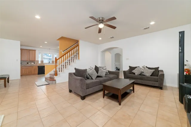 a living room with furniture and a ceiling fan