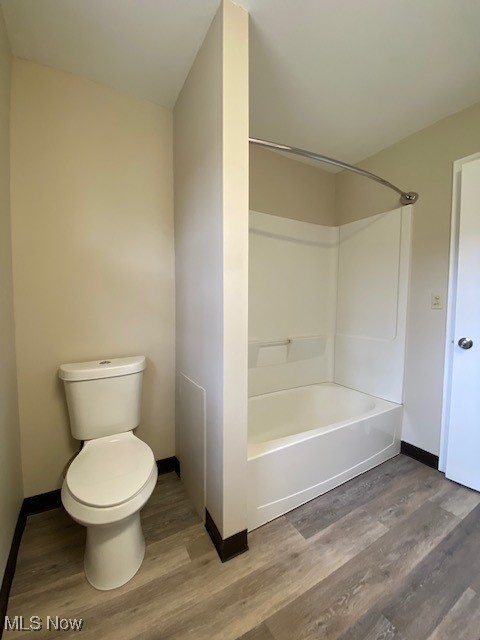 2868 Pressler Road Uniontown, OH 44685 - Photo 26 of 37 Bathroom featuring tub / shower combination, toilet, wood finished floors, and baseboards