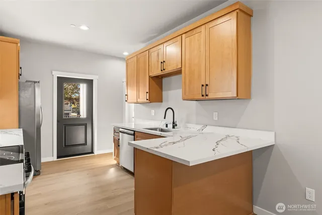 a view of a refrigerator a sink and dishwasher with wooden floor