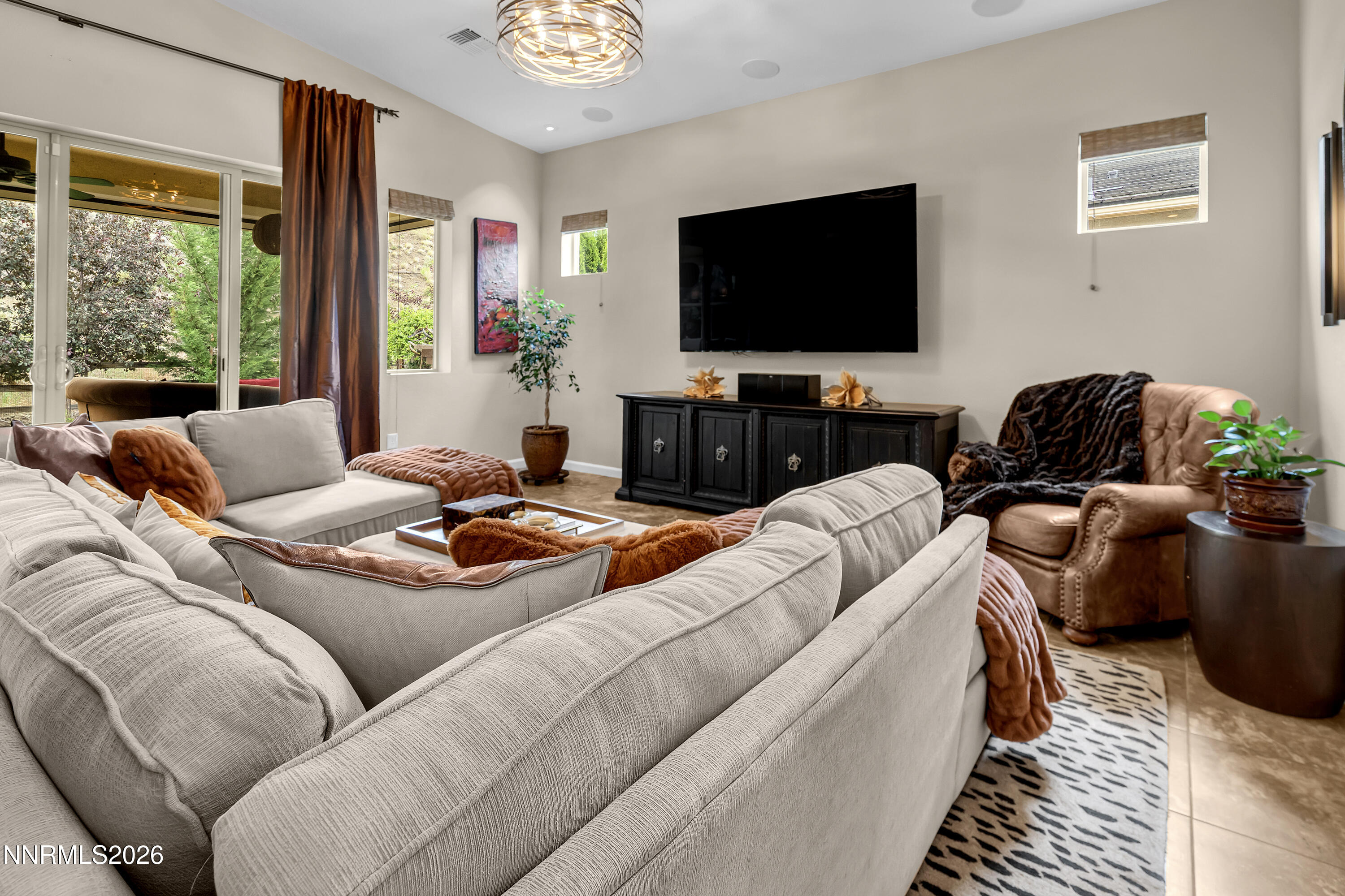 9021 Iron Sky Court Reno, NV 89523 - Photo 14 of 39 a living room with furniture a flat screen tv and a floor to ceiling window