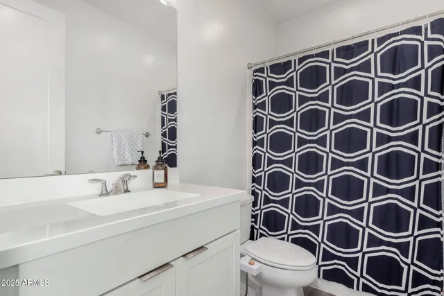 a bathroom with a shower curtain a sink and a mirror