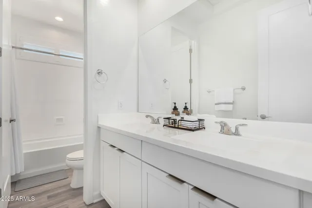 a bathroom with a double vanity sink toilet and shower