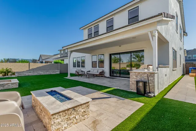 a view of a backyard with couches plants and large tree