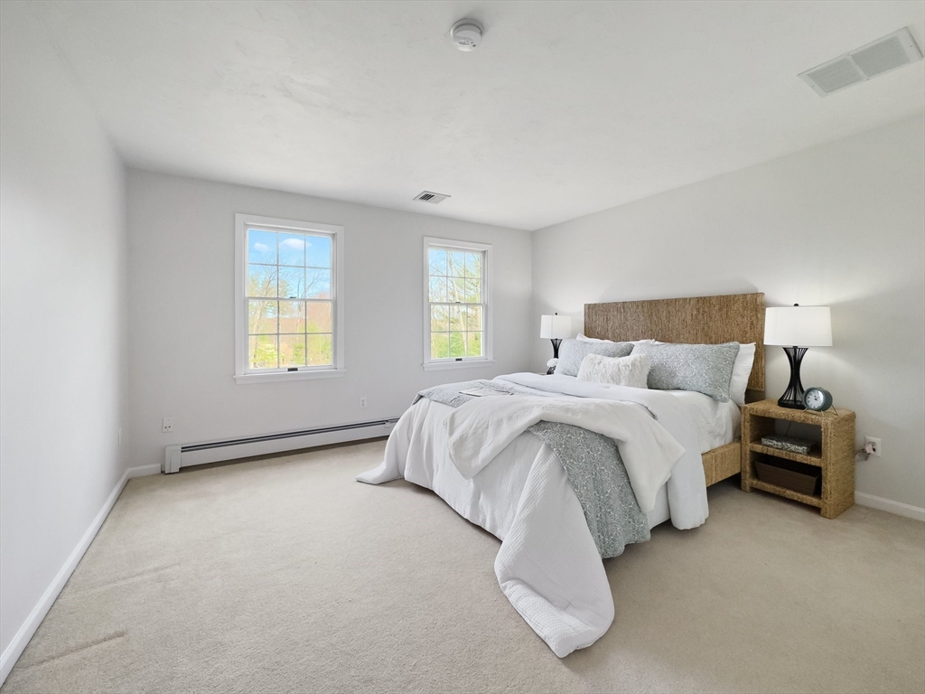 60 Golden Run Road Bolton, MA 01740 - Photo 23 of 42 a bed sitting in a spacious bedroom next to a window and a lamp
