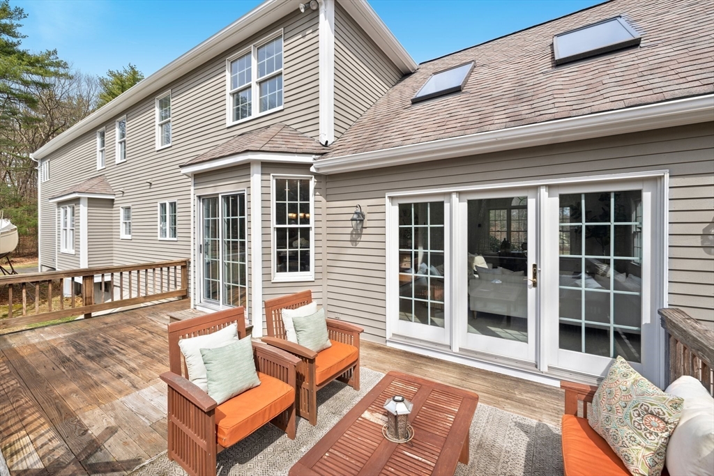 60 Golden Run Road Bolton, MA 01740 - Photo 38 of 42 a view of a patio with couches and a dining table and chairs with wooden floor