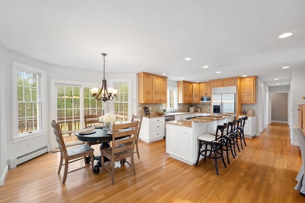 60 Golden Run Road Bolton, MA 01740 - Photo 7 of 42 a dining room with wooden floor a glass table and chairs