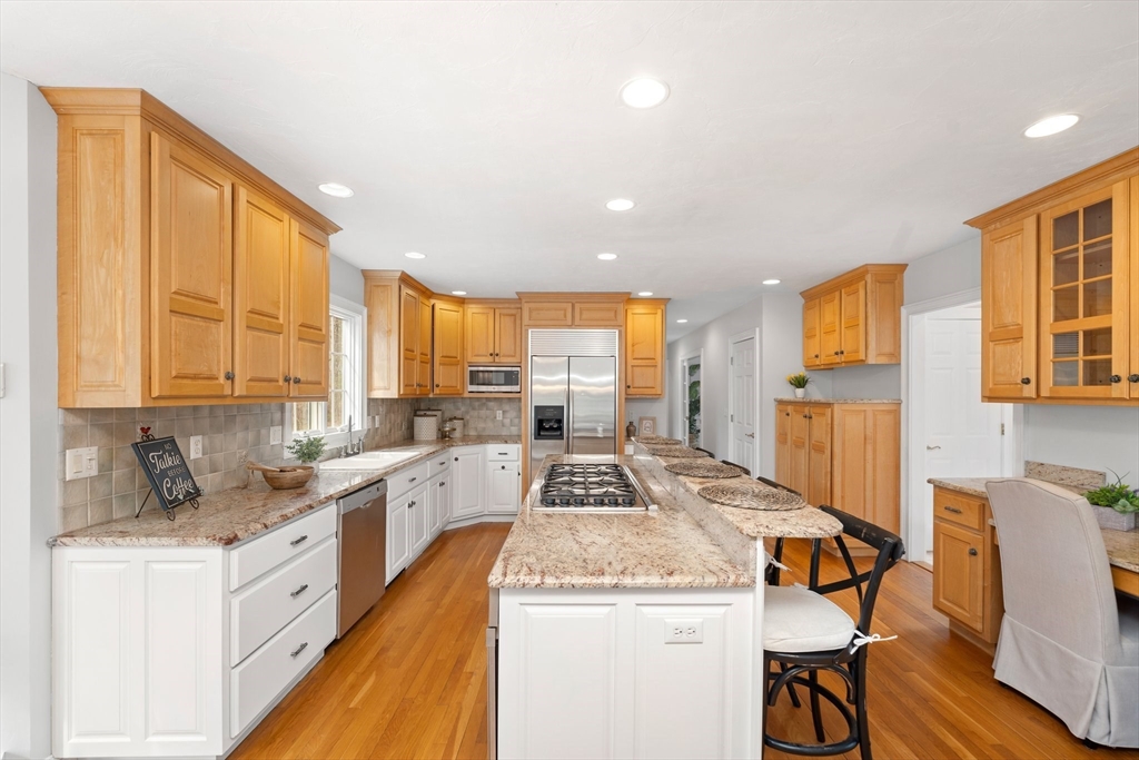 60 Golden Run Road Bolton, MA 01740 - Photo 8 of 42 a view of a kitchen with kitchen island granite countertop a stove top oven a sink a dining table and chairs