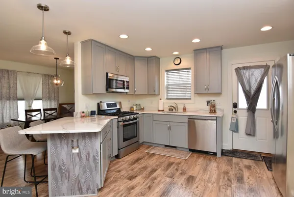 a kitchen with stainless steel appliances granite countertop a sink refrigerator and microwave