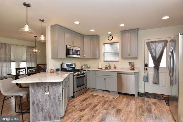 a kitchen with stainless steel appliances granite countertop a sink refrigerator and microwave