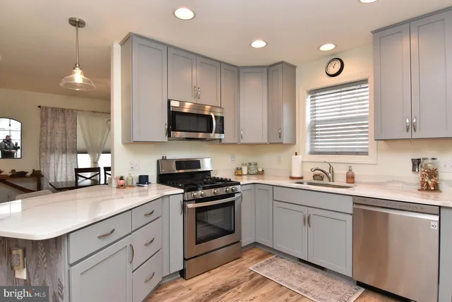 a kitchen with a sink a stove a microwave a refrigerator and cabinets