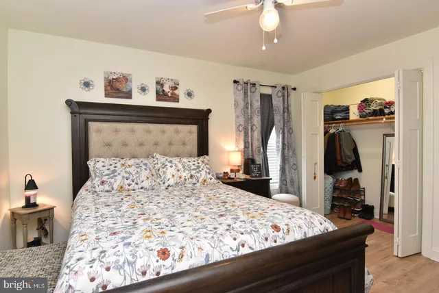 a bedroom with a bed and a mirror on the dresser