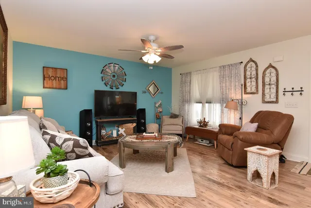 a living room with furniture a flat screen tv and a window
