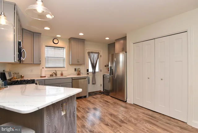 a kitchen with kitchen island a sink appliances and cabinets