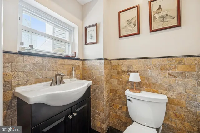 a bathroom with a sink mirror and a toilet