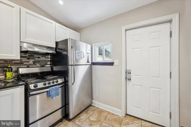 a kitchen with stainless steel appliances a refrigerator and a stove top oven