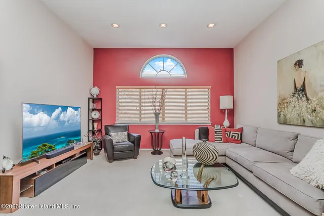 a living room with furniture a flat screen tv and a large window