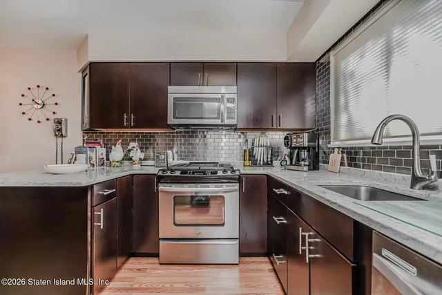 a kitchen with stainless steel appliances granite countertop a sink stove and cabinets