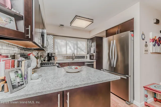 a kitchen with stainless steel appliances granite countertop a refrigerator and a sink
