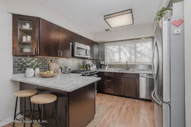 a kitchen with stainless steel appliances granite countertop a sink and wooden cabinets
