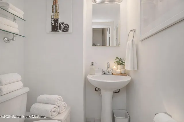 a bathroom with a sink a toilet and mirror
