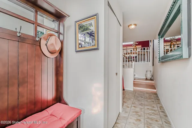 a hallway with painting on the wall and a large mirror