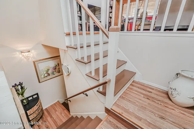 a view of staircase with lots of frames on wall and a window