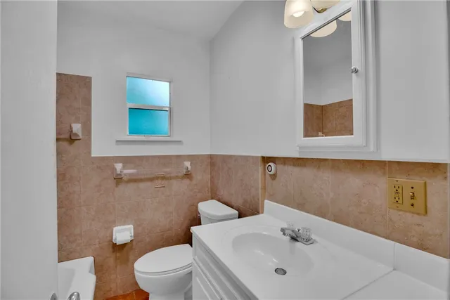 a bathroom with a toilet sink and mirror