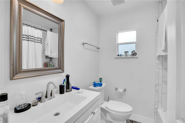 a bathroom with a sink a toilet and a mirror