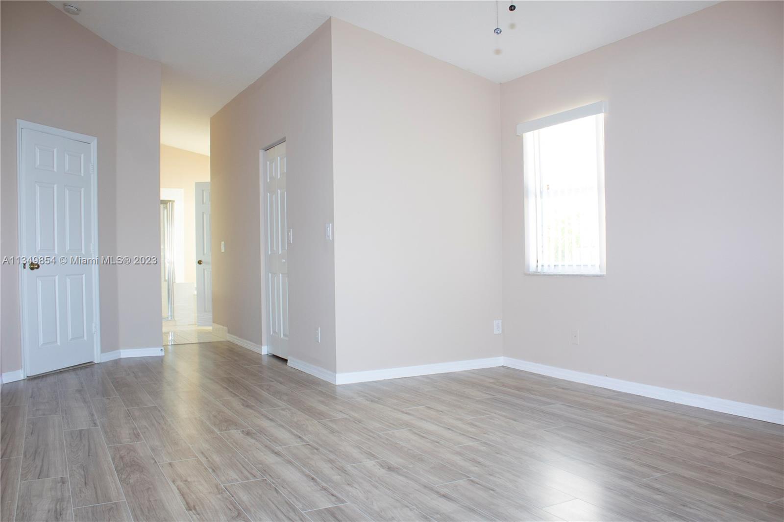 13221 Southwest 53rd Street Miramar, FL 33027 - Photo 17 of 32 an empty room with wooden floor and a window