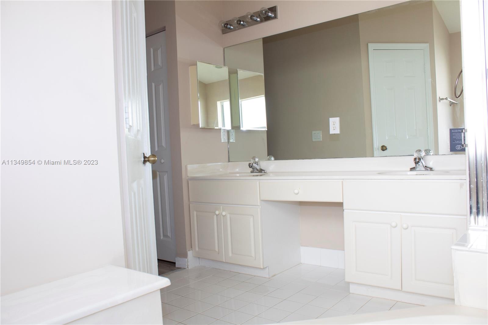 13221 Southwest 53rd Street Miramar, FL 33027 - Photo 22 of 32 a bathroom with a sink and a mirror