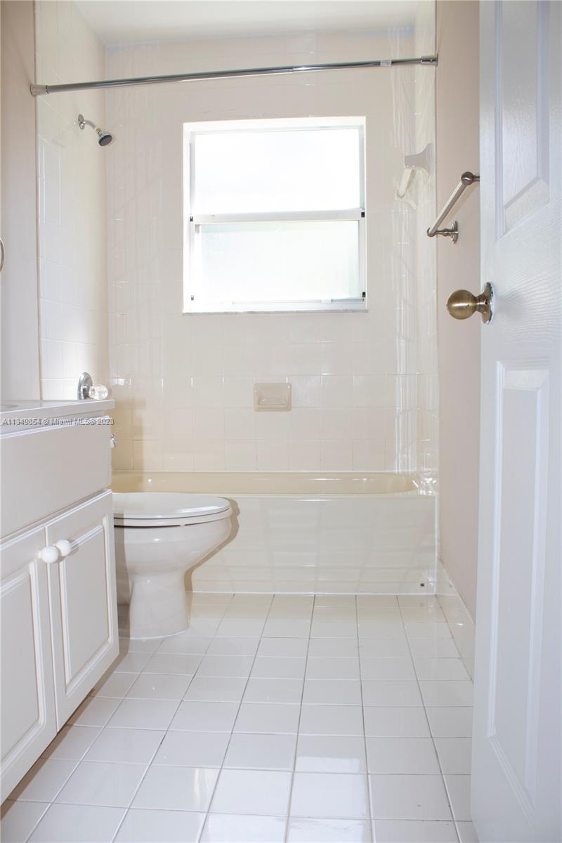 13221 Southwest 53rd Street Miramar, FL 33027 - Photo 23 of 32 a bathroom with a toilet a sink a vanity and mirror