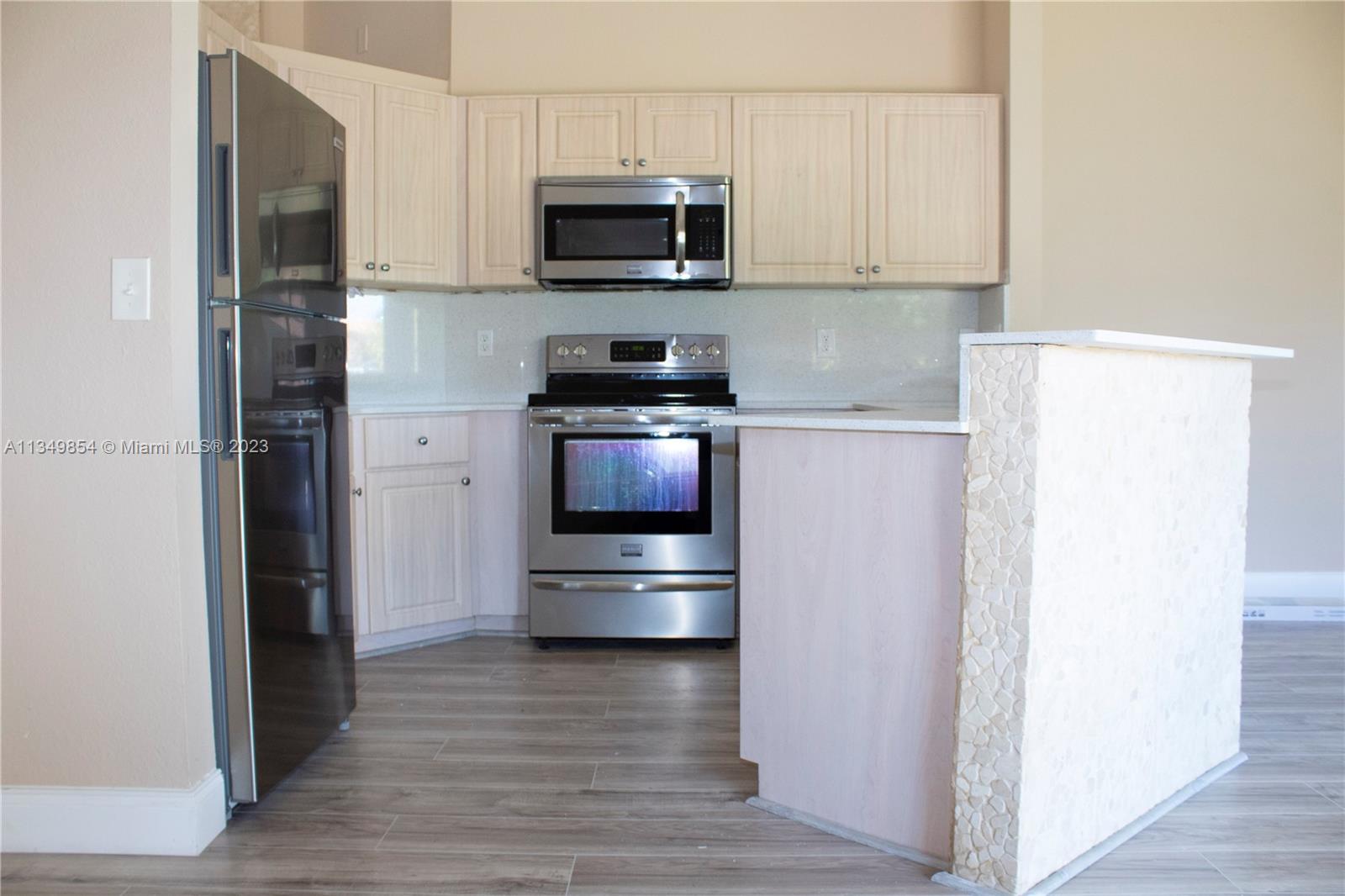 13221 Southwest 53rd Street Miramar, FL 33027 - Photo 27 of 32 a kitchen with stainless steel appliances and granite countertop a refrigerator