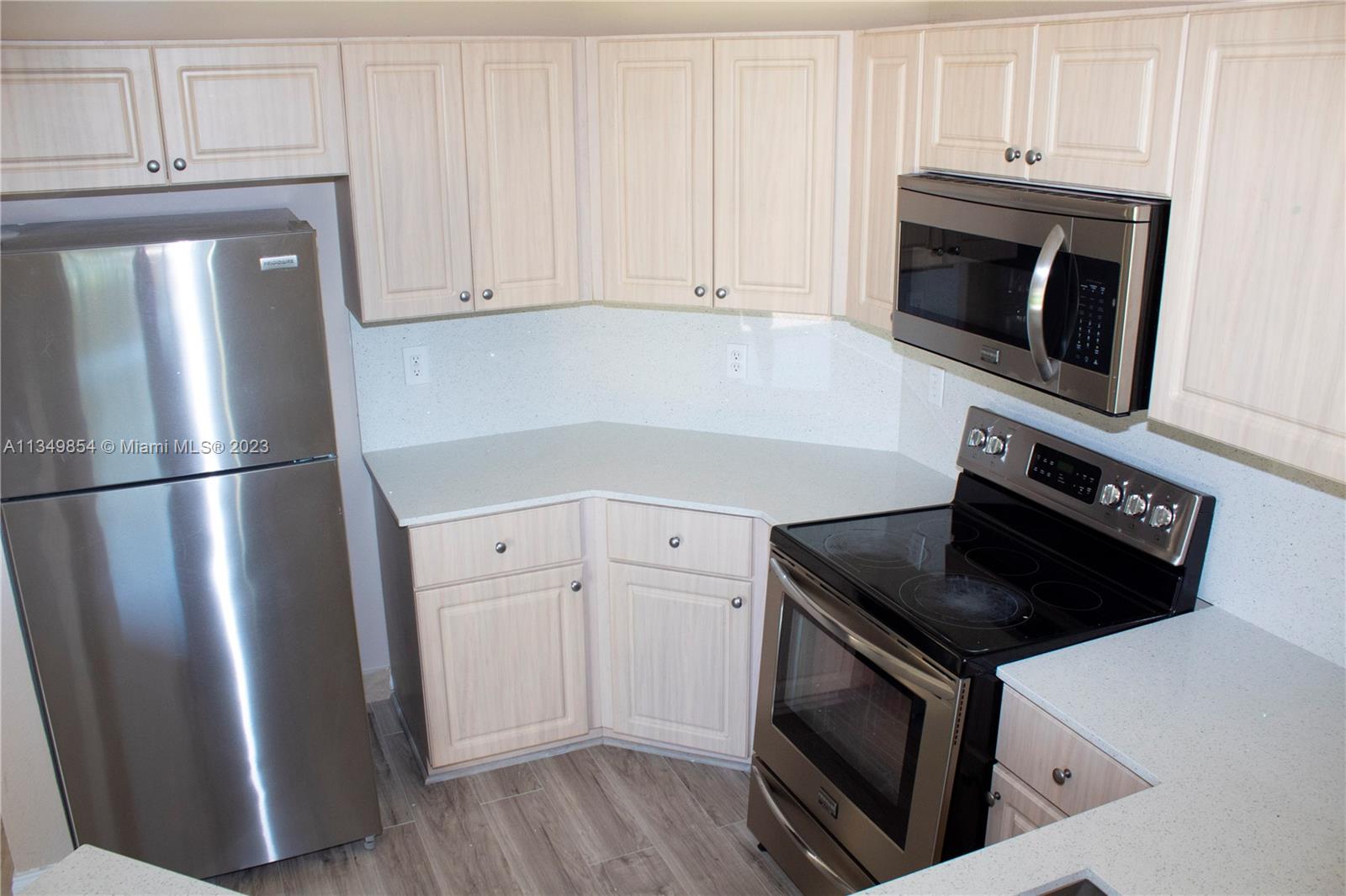 13221 Southwest 53rd Street Miramar, FL 33027 - Photo 29 of 32 a kitchen with granite countertop white cabinets and stainless steel appliances