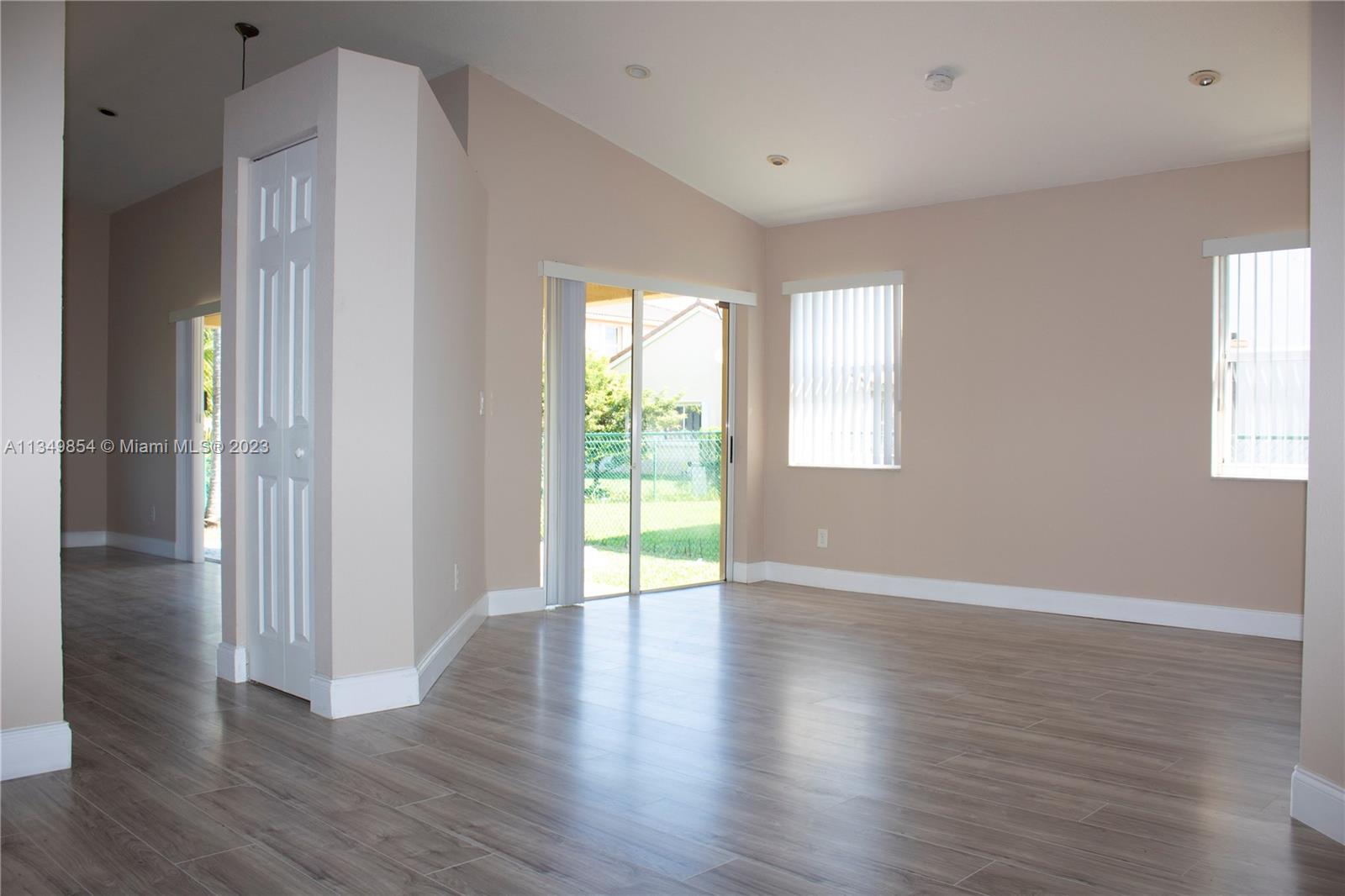 13221 Southwest 53rd Street Miramar, FL 33027 - Photo 9 of 32 a view of an empty room with wooden floor and a window