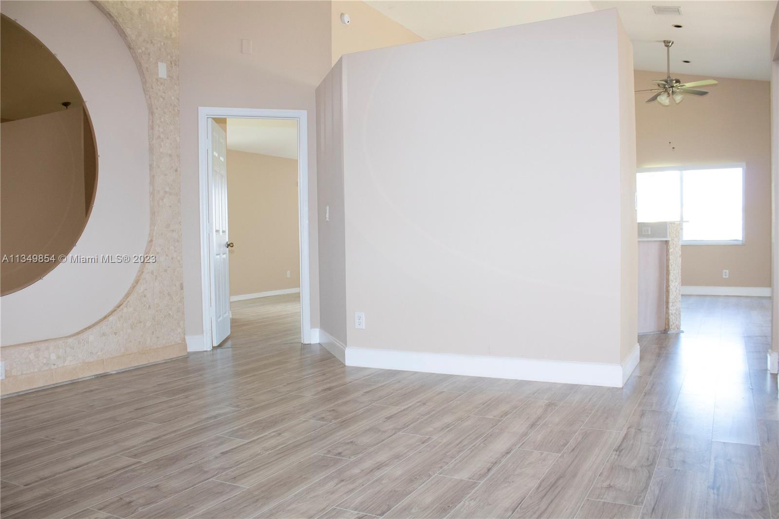 13221 Southwest 53rd Street Miramar, FL 33027 - Photo 10 of 32 an empty room with wooden floor and windows