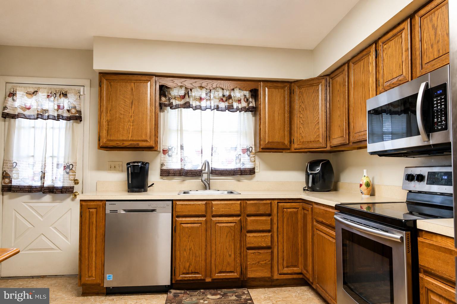 8121 Elizabeth Road Pasadena, MD 21122 - Photo 4 of 27 a kitchen with stainless steel appliances granite countertop a sink stove and microwave