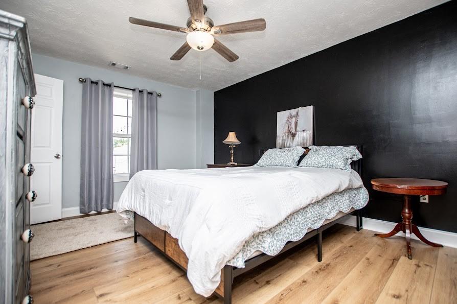 575 Liberty Church Road Carrollton, GA 30116 - Photo 51 of 95 a bedroom with a large bed and a chandelier
