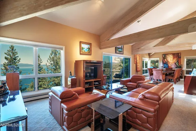 a living room with furniture a large window and a flat screen tv