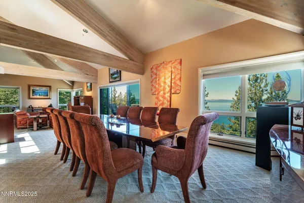 a dining room with furniture and a floor to ceiling window