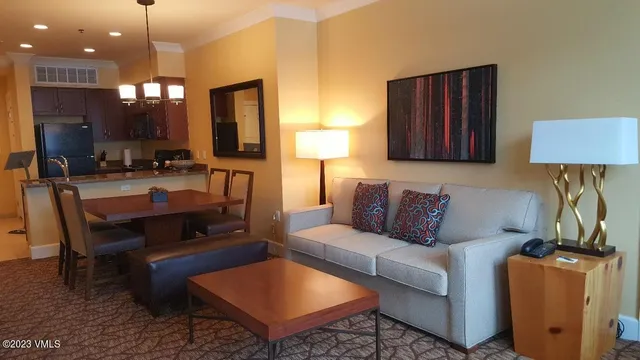 a living room with furniture a flat screen tv and kitchen view
