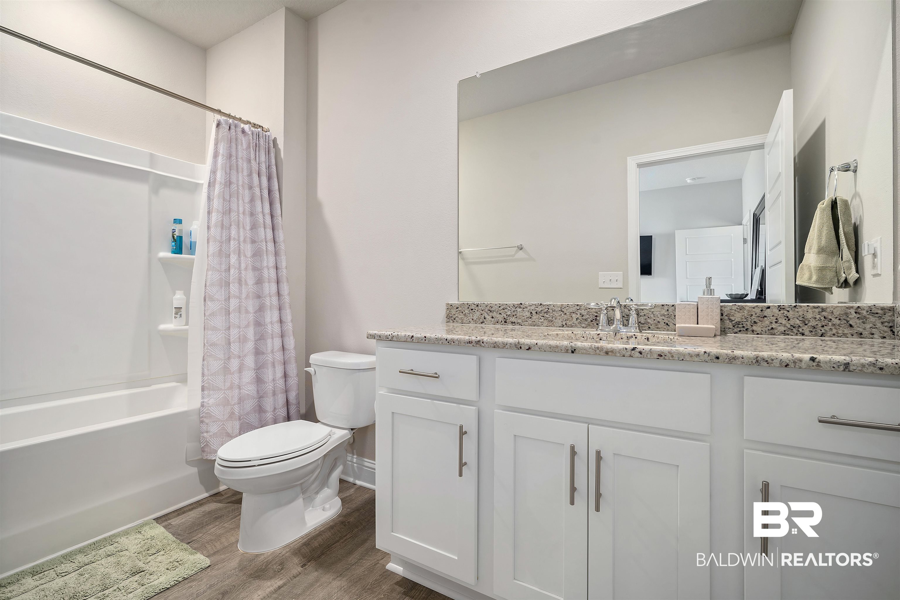 1700 Gwin Court Mobile, AL 36695 - Photo 29 of 36 Full bath with vanity, dark wood finished floors, and shower / bath combo with shower curtain